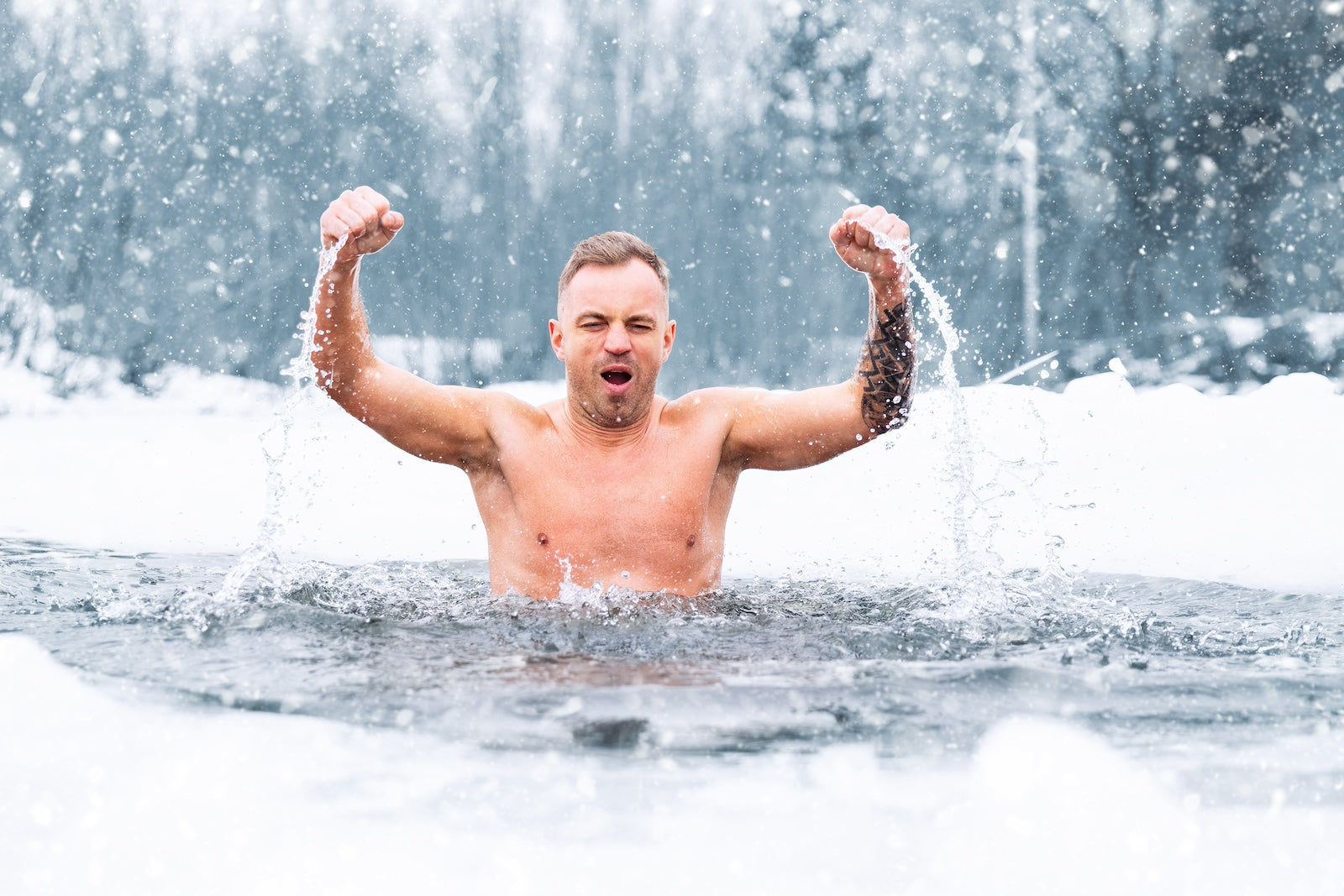 Persoon bevindt zich in ijskoud water omringd door sneeuw.