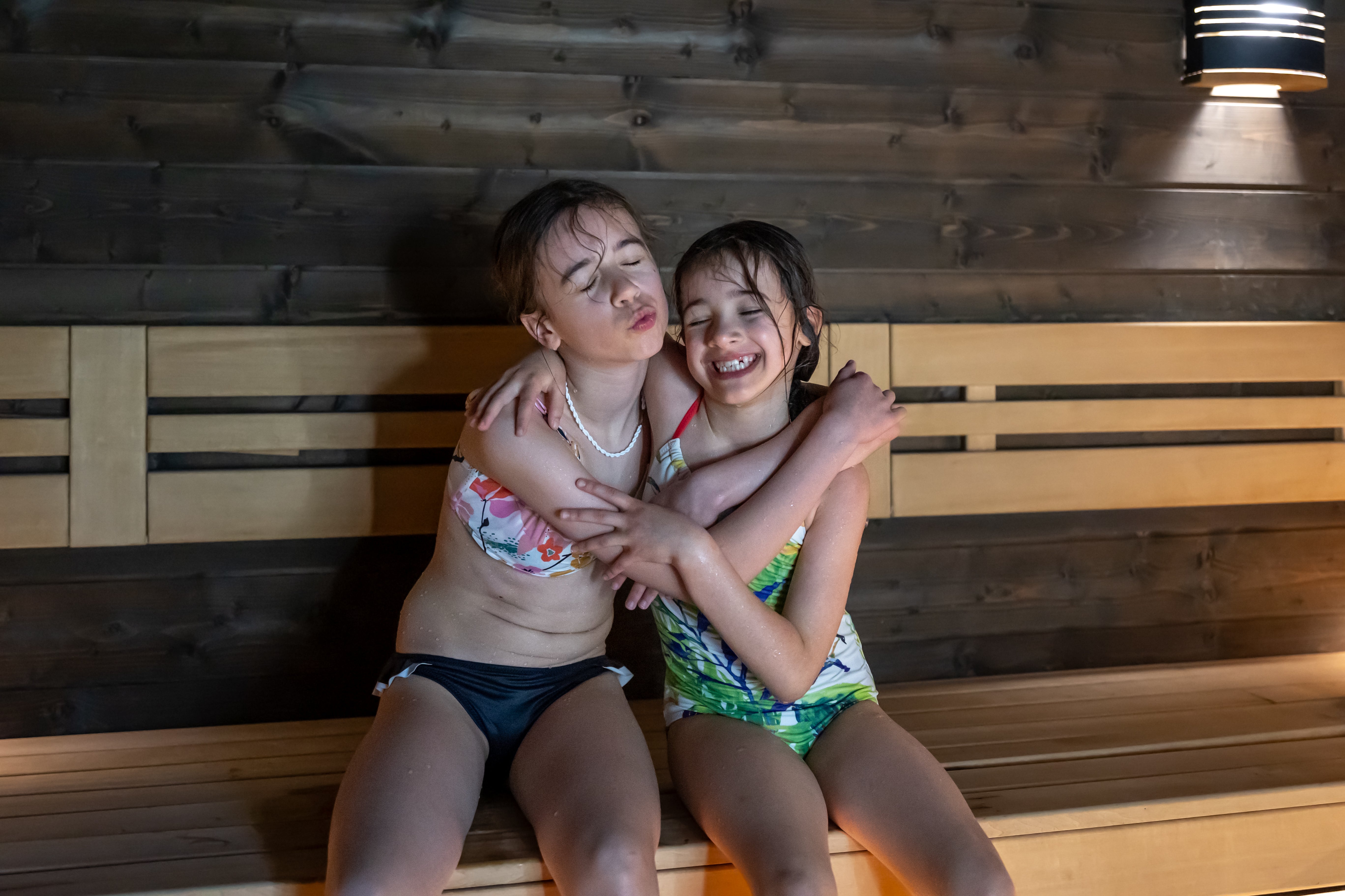 Twee kinderen genieten samen van een rustig moment in de buitensauna