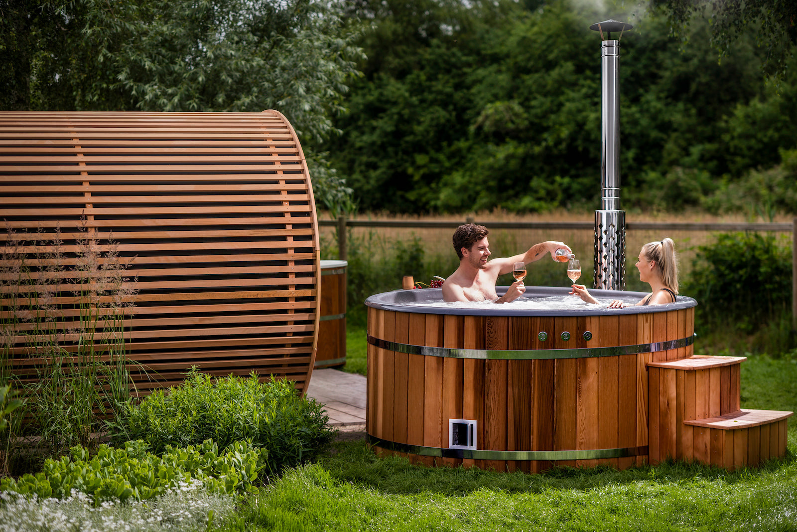 Een koppel ontspant in hun hottub in de tuin, genietend van een drankje en elkaars gezelschap.